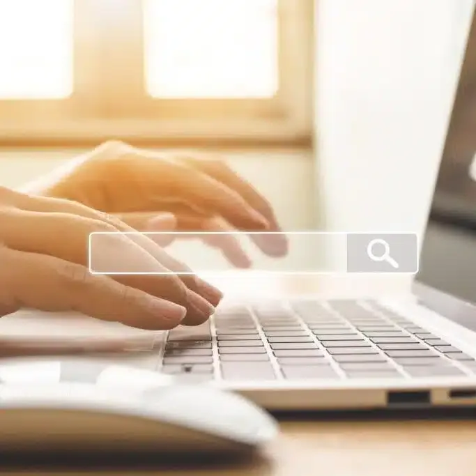 Hands typing on a laptop keyboard with a search bar, symbolizing digital marketing and online visibility for hospitality businesses.
