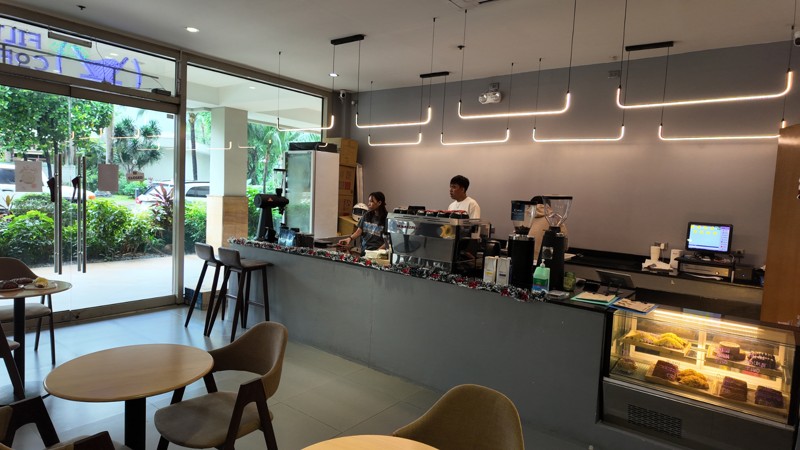 Coffee shop interior with baristas at the counter, showcasing local business ambiance and inviting atmosphere for customers seeking refreshments.