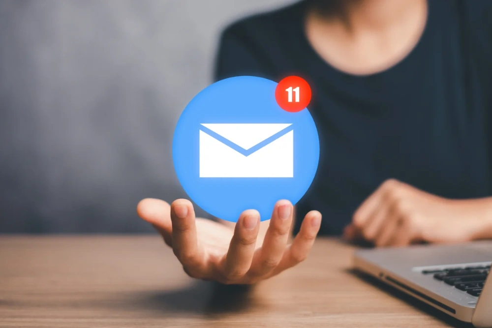 Business owner holding a smartphone displaying customer inbox and follow-up notifications